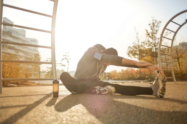 Man stretching outdoors with sunrise background showing vitality